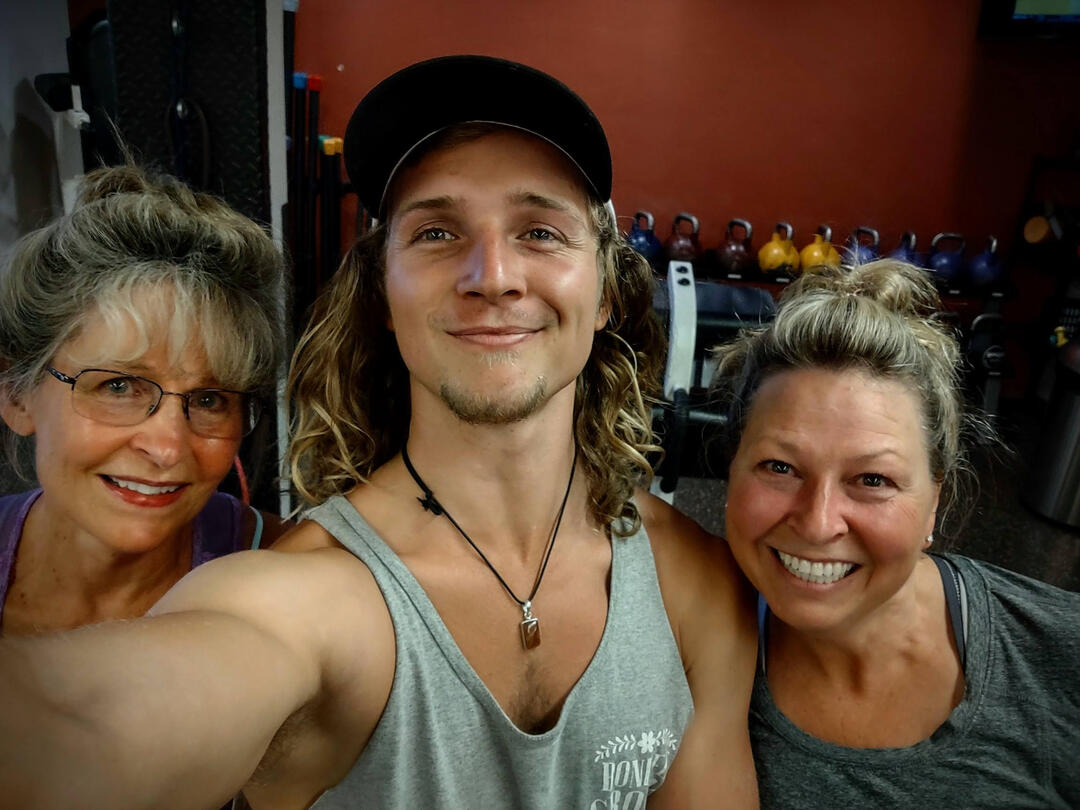 Training with clients 3 people smiling in gym